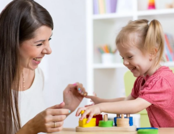 ot therapist using play-based activities as therapy with blonde child