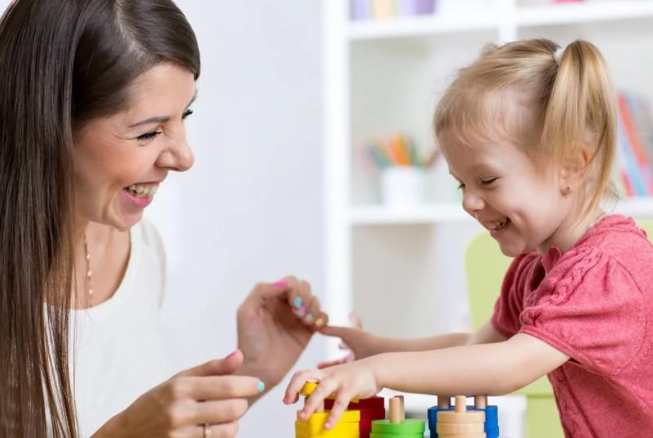 ot therapist using play-based activities as therapy with blonde child
